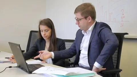 Head indicates to female employee errors that made on sheet in office. Stock Footage 83108995