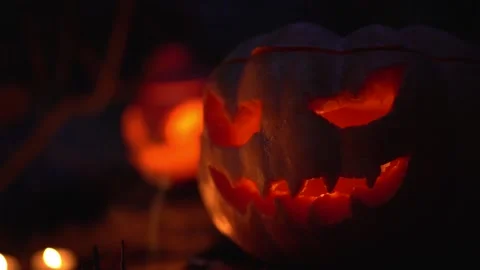 Head jack lantern with burning candle inside in night autumn forest outdoors.  Stock Footage 139202109