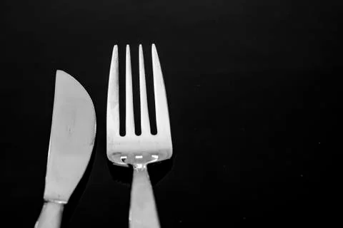 Head of knife and fork on black background Stock Photos