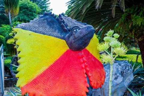 The head of the lizard is painted red and yellow Stock Photos