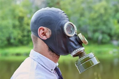 Head in the mask, in profile on a background of the river and the forest 스톡 사진