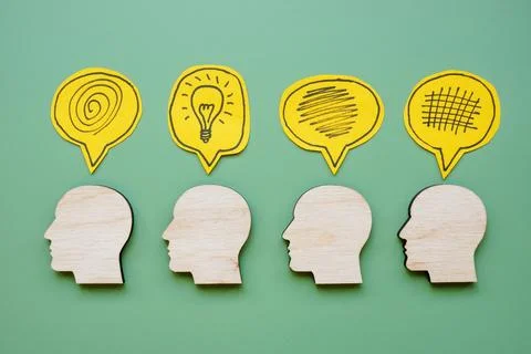 Head outlines with one featuring light bulb. Creative thinking concept. Stock Photos