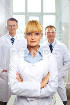 Head physician portrait of female doctor standing in front of her male colleague Stock Photos