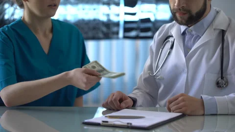 Head physician refusing bribe at clinic, female intern giving money to doctor Stock Footage 91892190