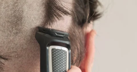 Head is shaved bald with trimmer. Back view, close-up back head, ear. Stock Footage 256089141
