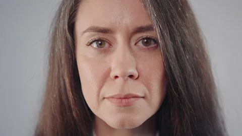 Head shot face portrait middle aged caucasian brunette woman on grey background Video stock 236726974