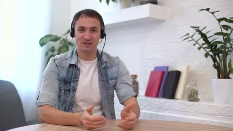Head shot millennial guy sit in living room makes video call looks at camera Stock Footage 147024979