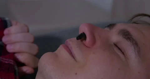 Head of sleeping man black snot sticks out nostril, insect crawled into nose Stock Footage 214147773