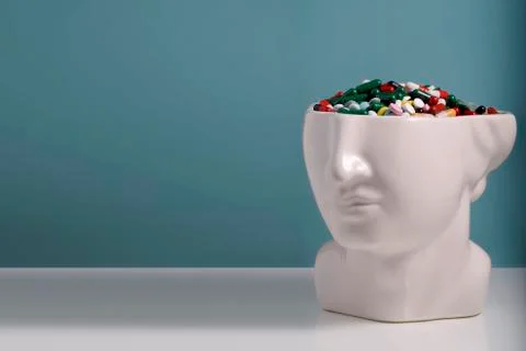 The head of a statue with a pill brain. Concept: Mind and medicine. Blue back Stock Photos