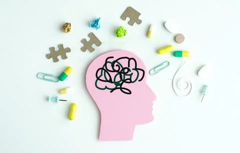 A head with a tangled mess of string and pills on it. The pills are yellow .. Stockfoto's