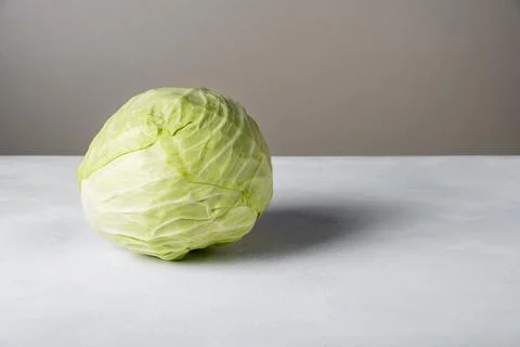 Head of white cabbage lies on surface. Stock Photos