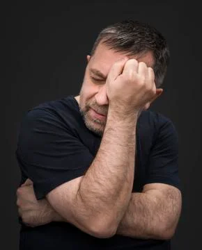 Headache. man with face closed by hand Stock Photos