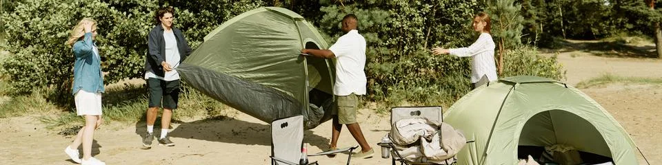 Header of Diverse Group of Friends Setting up Camping Tent in Nature Stock Photos