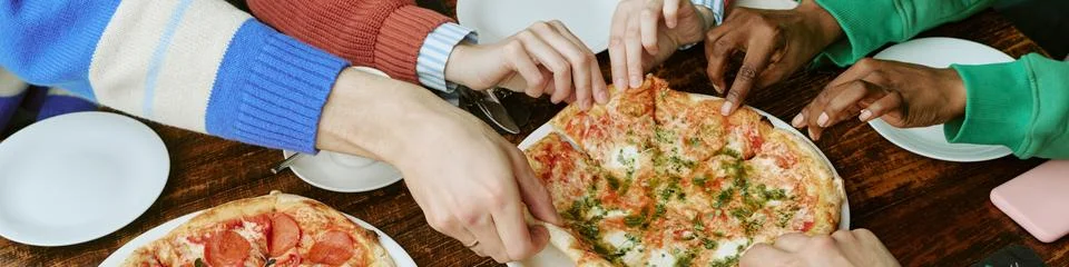 Header of Diverse Group of Friends Sharing Fresh Italian Pizza in Restaurant Stock Photos