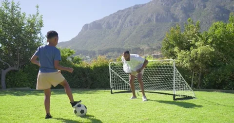 Header drill African American father and teenage son bumping ball practicing Stock Footage 340969394