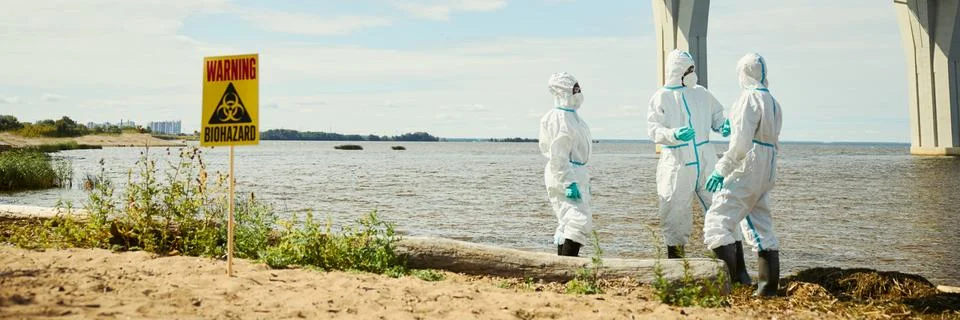 Header of Ecologists in Protective Suits Inspecting Biohazard Water Pollution Stock Photos