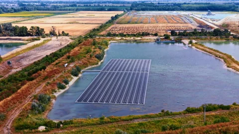 Heading to the artificial lake with floating solar panel arrays. Photovoltaic 動画素材 346190202
