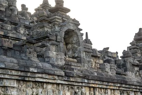 A headless Buddha statue sits in a stone niche on Borobudur temples ancient.. Stock Photos