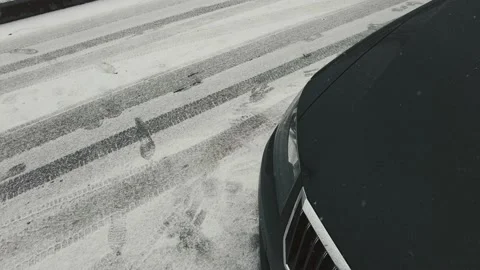 Headlight of a black car on the right snow is falling winter late spring Stock Footage 175963148