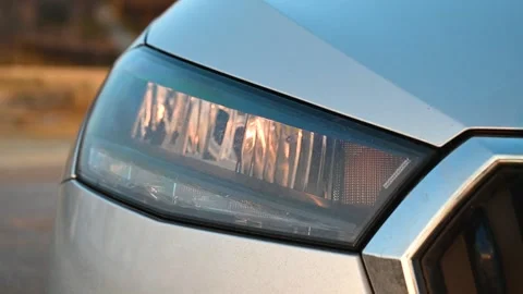Headlight of a car, close up. Front lights of the grey car on parking. Stock Footage 297008230