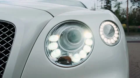 Headlight close-up. The headlights on a white luxury car are on. Stock Footage 131879034
