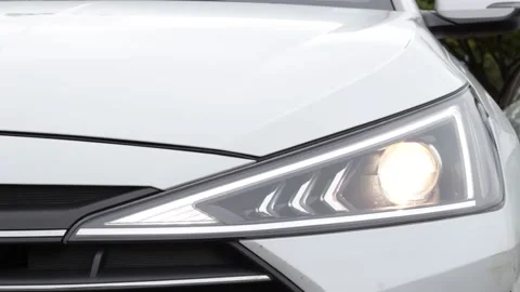Headlight flashes on a white car close-up front view. Stock Footage 163186425