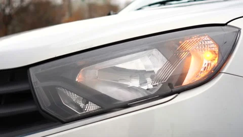 Headlight of gray car close-up with flashing turn signal. Car alarm on. Security Stock Footage 165871706