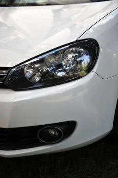 Headlight of the main light of the white car, close-up. Stock Photos
