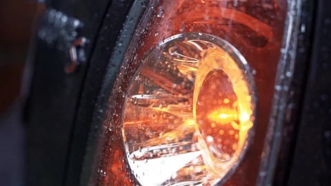 Headlight of modern car flashes. Black car headlight close-up, yellow light Stock Footage 112796372