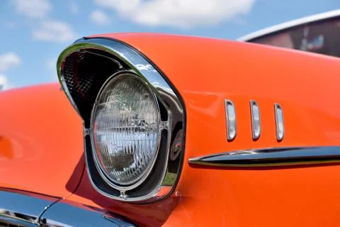 Headlight retro car on background of cloudy sky. Vintage. Stock Photos