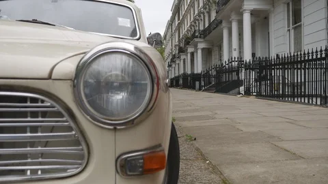 The headlight of a retro car beside a row of terraced houses. Stock Footage 107074411