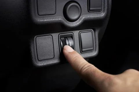 Headlight switch level adjustment by driver hand. Stock Photos