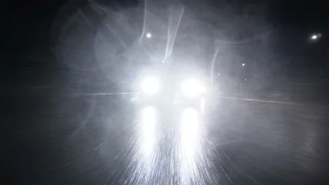Headlights car shine brightly into camera through rain, while driving asphalt Stock Footage 232339434