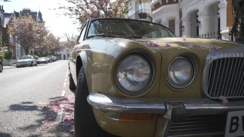 The headlights of a retro car with a blossoming tree in the background. Stock Footage 106823987