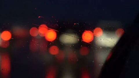 Headlights through the wet window of a car Stock Footage 78603794