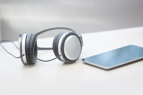 Headphones and tablet computer on a table Stock Photos