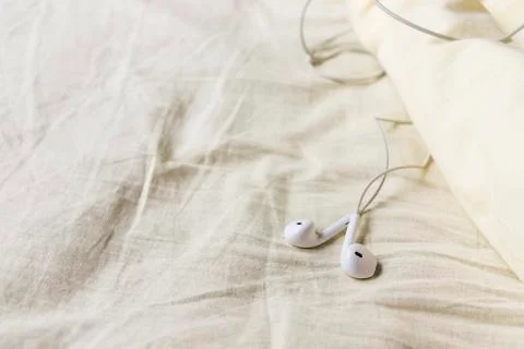 Headphones are in rumpled bed Stock Photos