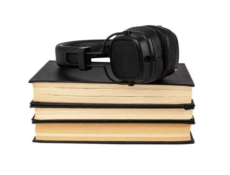 Headphones on books stack isolated on white background. Listening to audioboo Stock Photos