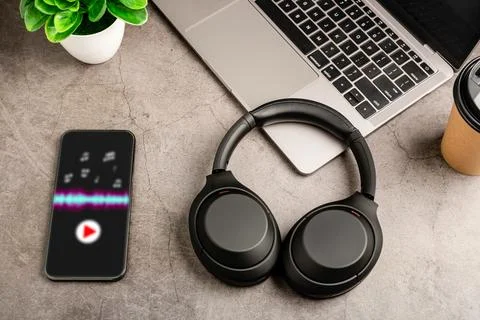 Headphones on a gray work table. The concept of playing music with smartphone Stock Photos