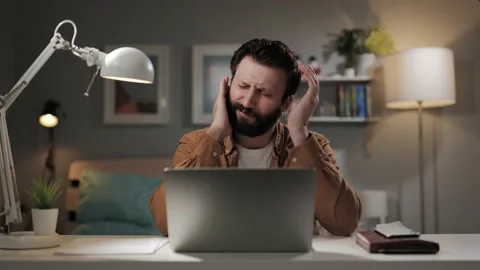 Headphones press on ears. User experiences pain from headphones. Sad tired man 動画素材 196201747