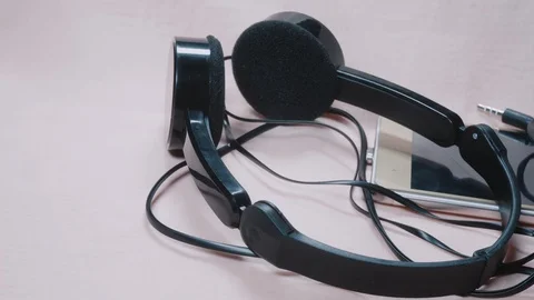 Headphones, smartphone and computer mouse close-up 4K Stock Footage 100707626