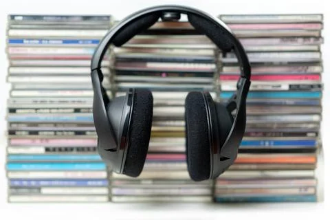 Headphones on a stack of CDs on isolate white background. Stock Photos