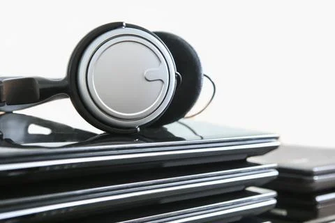 Headphones on stack of laptops Stock Photos