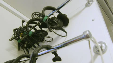 Headphones for workers hang on metal pipe in storage room Stock Footage 234318005