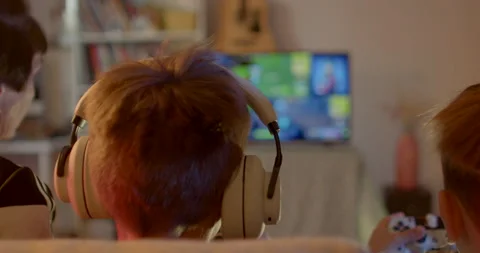 Heads boys sitting sofa play video games grandmother controls grandchildren Stock Footage 202045452