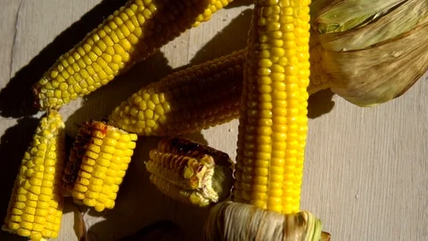 Heads of fried corn are on the table and sprinkled with salt . close up. corn's Stock Footage 91699922
