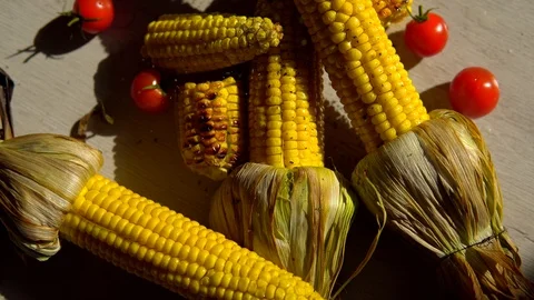 Heads of fried corn are on the table and sprinkled with salt . close up. corn's Stock Footage 91700133