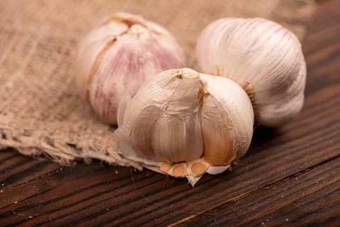 Heads of young garlic on a table covered with burlap, close-up, selective foc Stock Photos