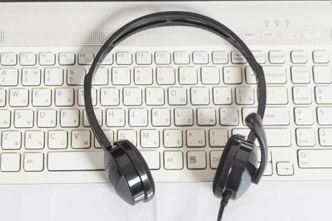 Headset with laptop computer keyboard.Communication concept Stock Photos