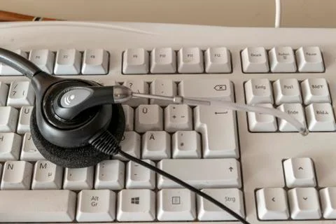 Headset for phone on the computer keyboard both dirty Stock Photos